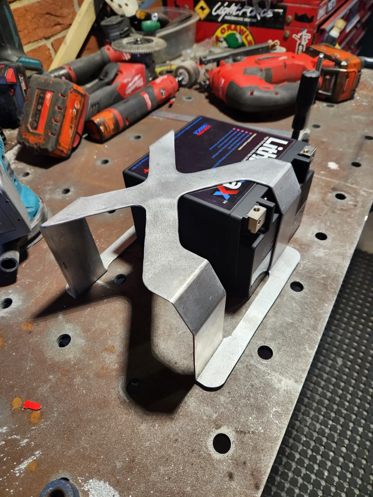 Aluminium battery box holding a lithium battery on a welding table