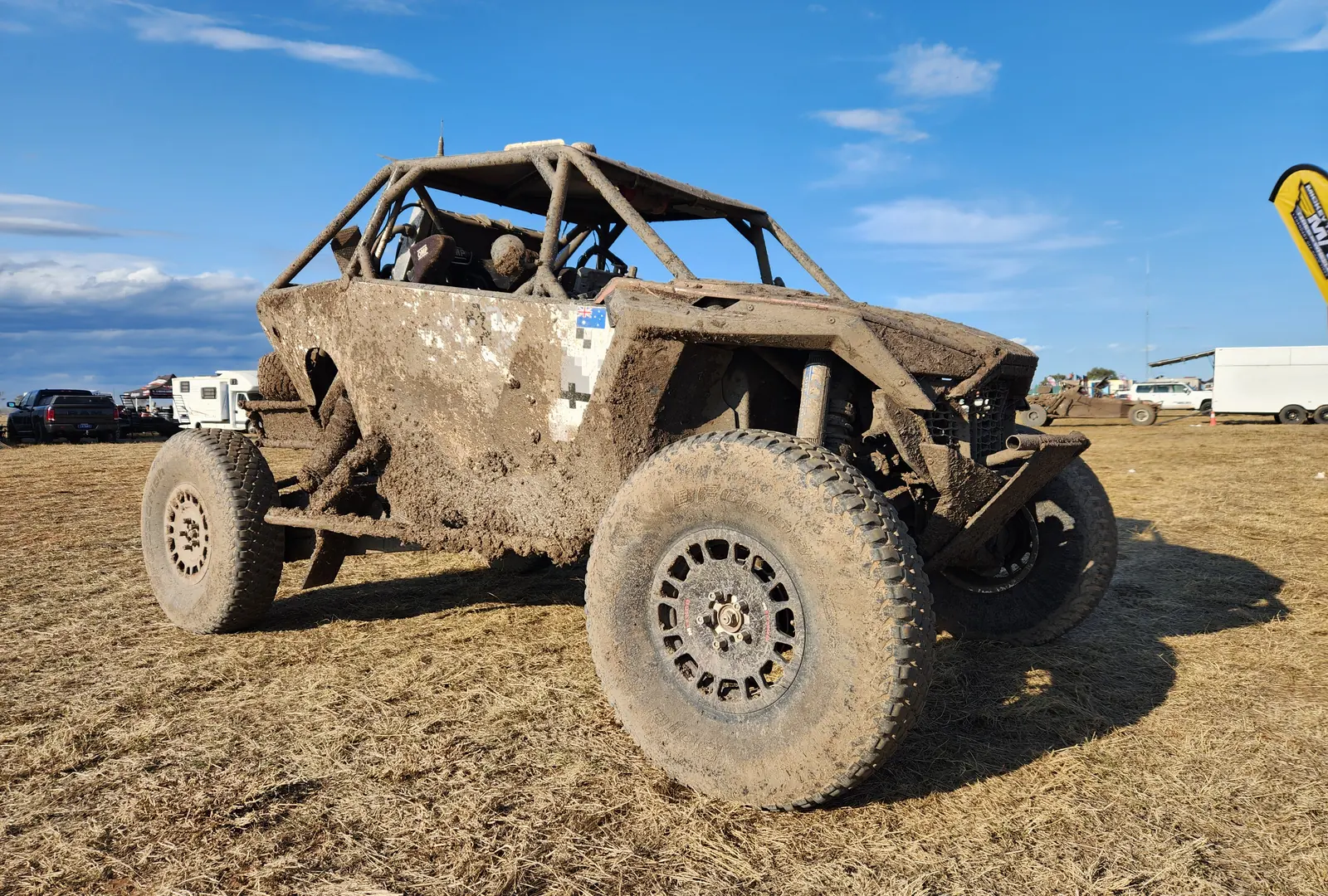 The buggy covered in mud in the pits after a race
