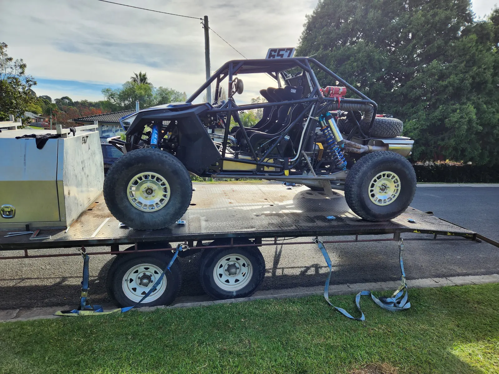 Buggy strapped down on a car trailer