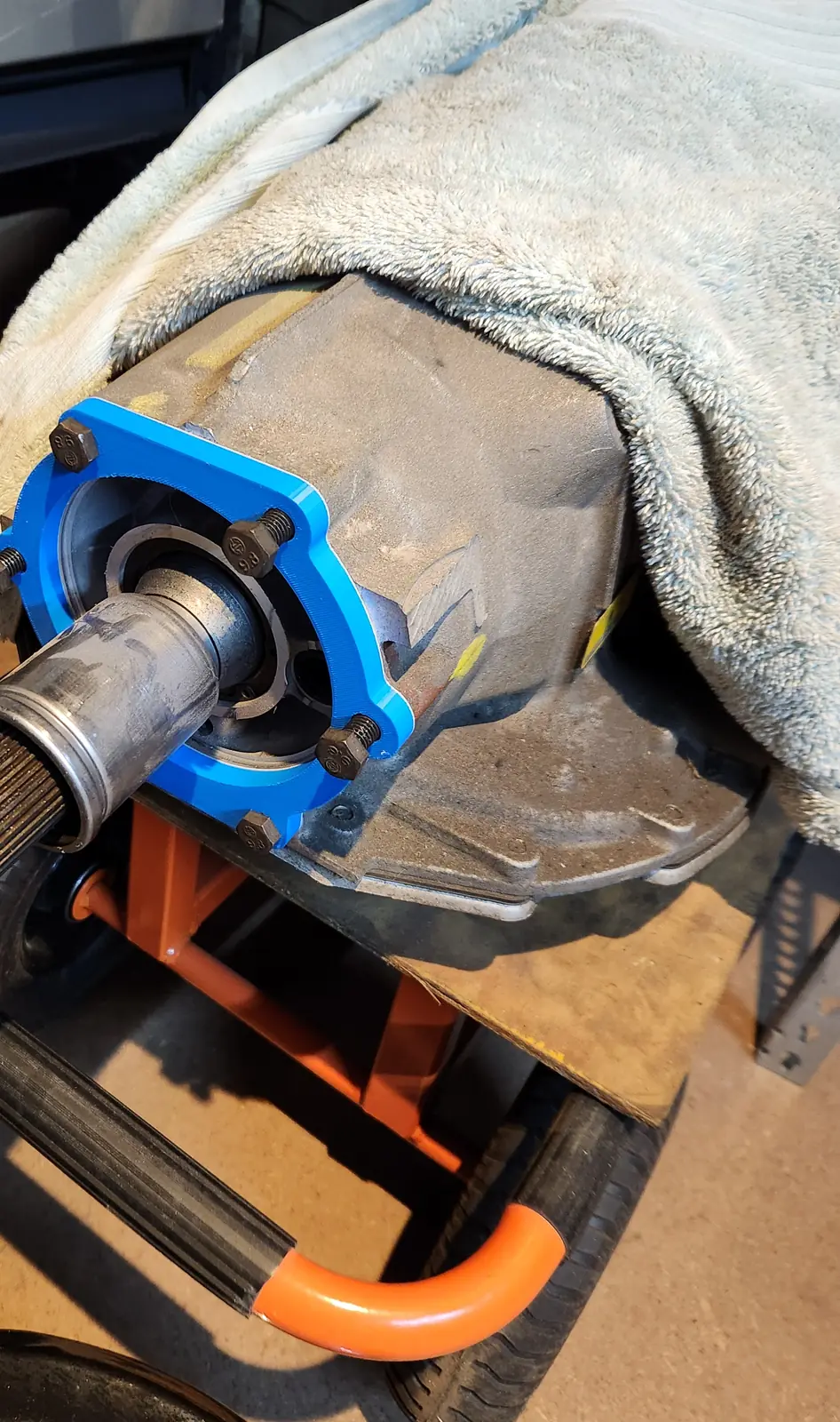 Blue 3D-printed adapter fitted to the output end of a 4L80e transmission