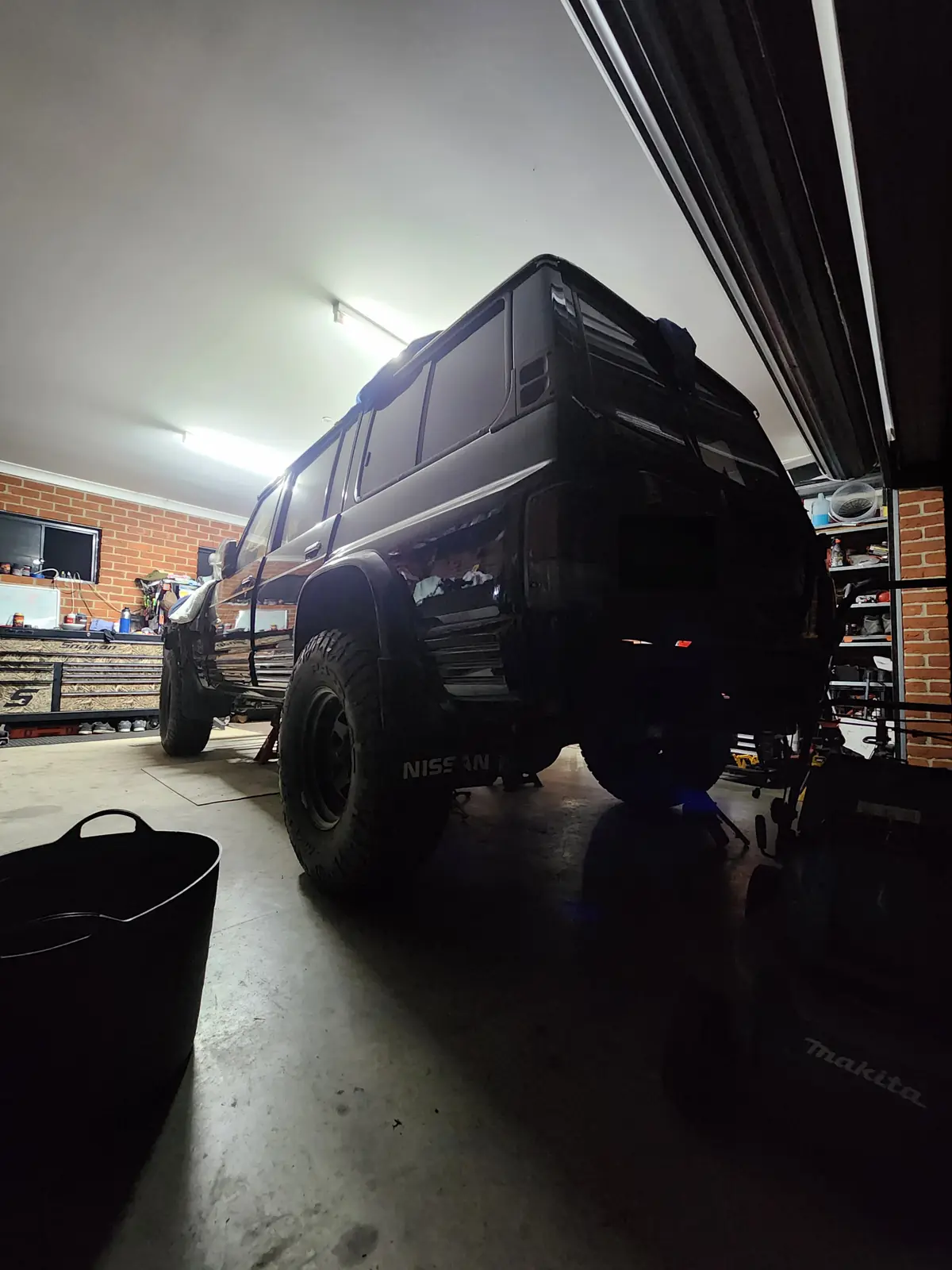 The Patrol sitting on its wheels in the garage at night