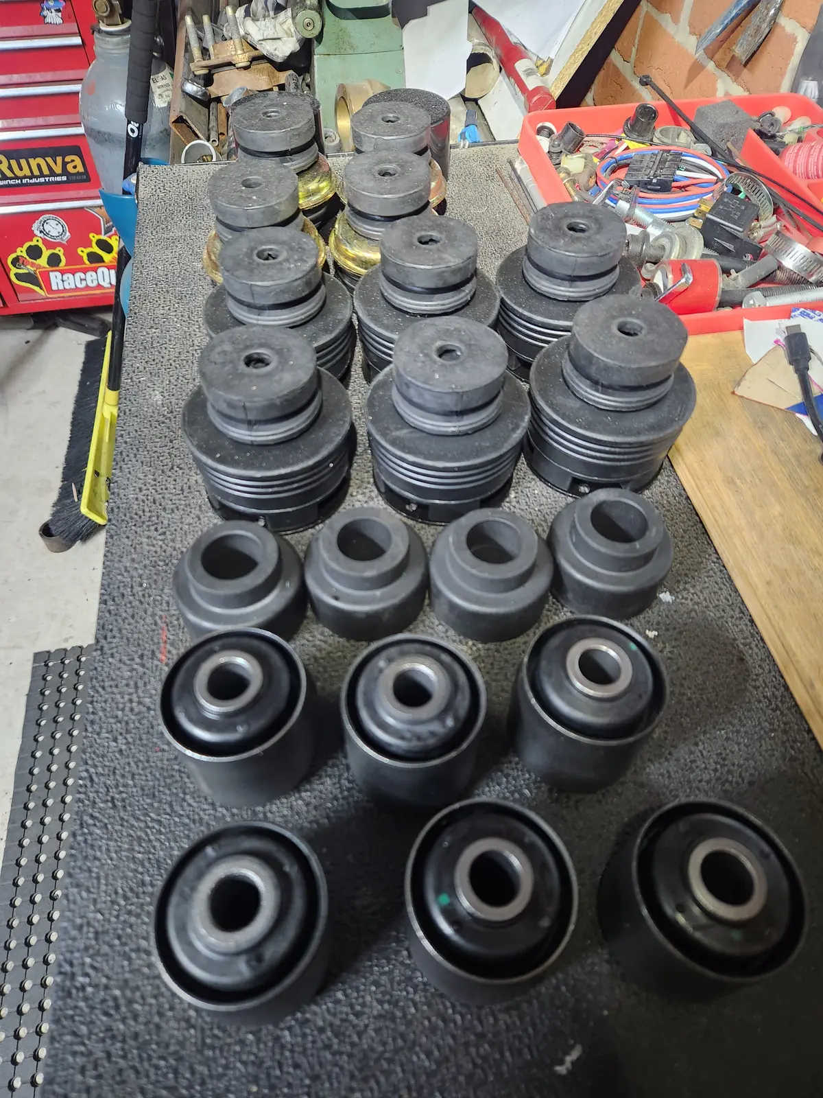 Rows of new rubber body mount bushes on a bench